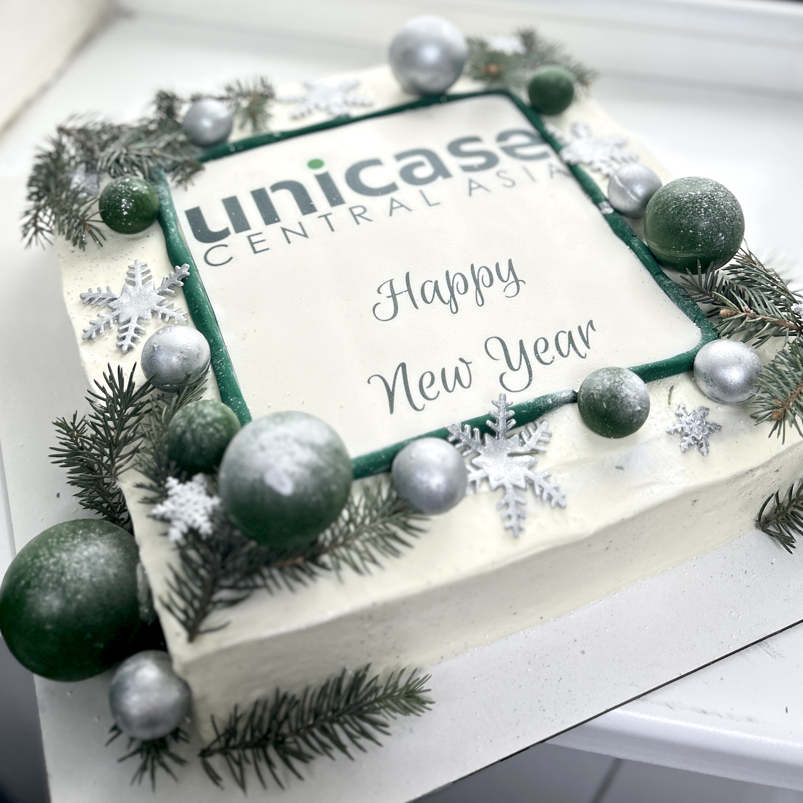 Новогодний торт с логотипом компании, шоколадными шарами и еловыми ветками Алматы