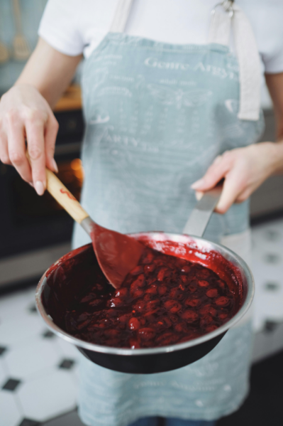 chef adding powder to hot sauce pan kitchen